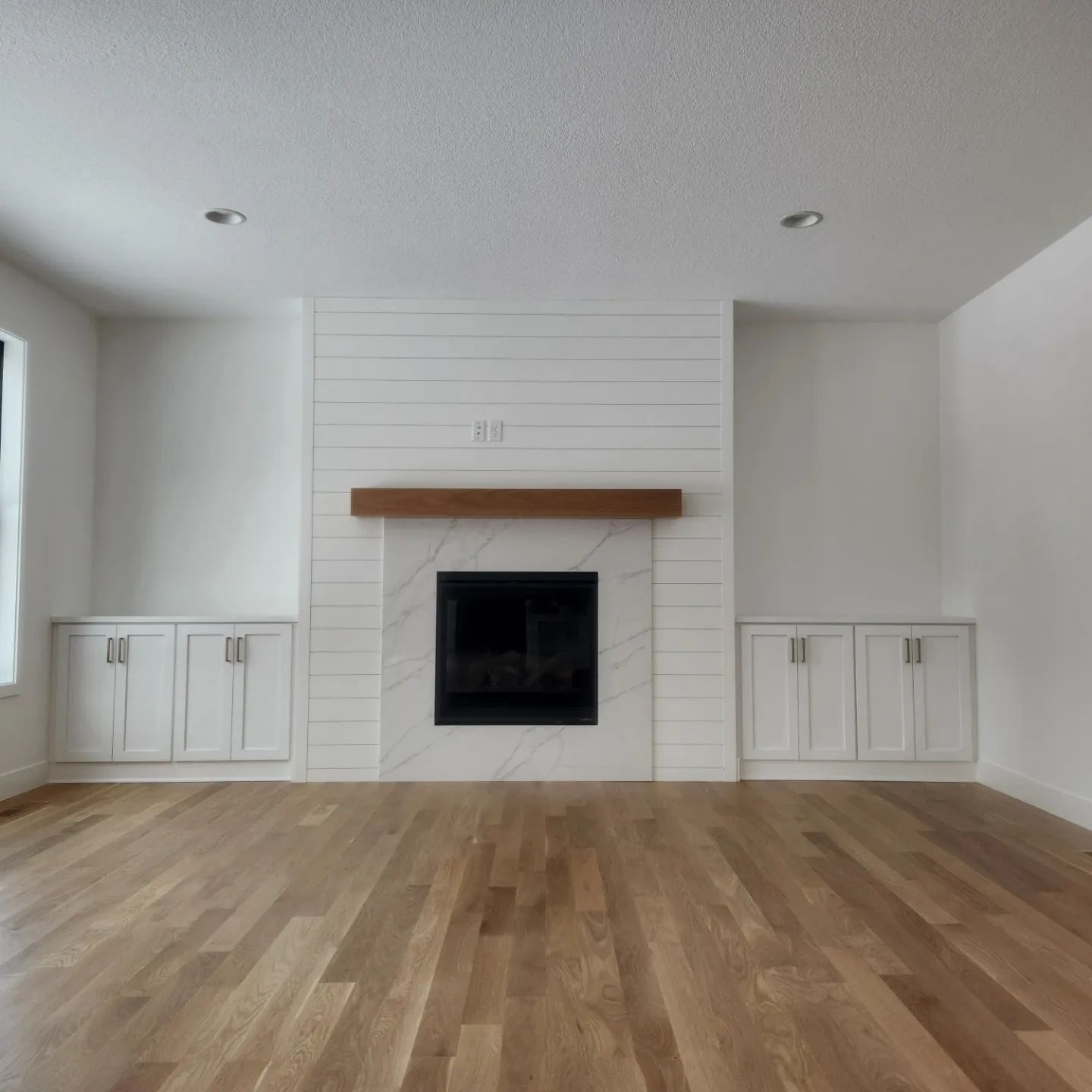 White painted fireplace surround and built-ins in a bright living room