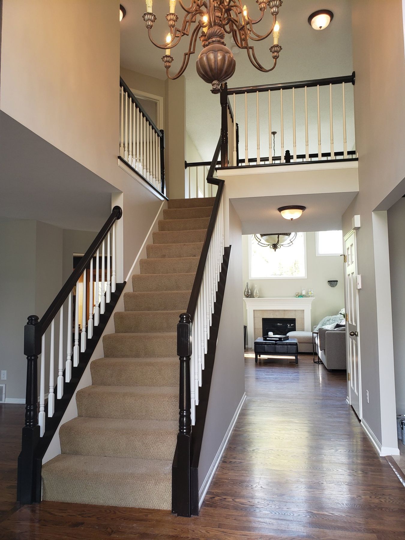 After: Staircase and landing: golden oak rails to espresso with white balusters