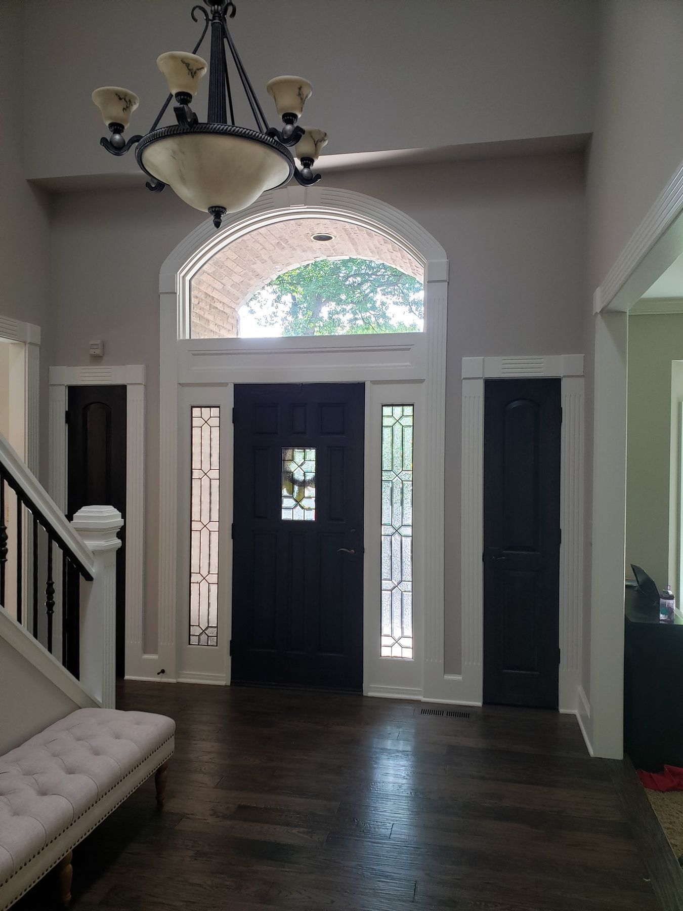 Foyer with oak trim painted white and the front door painted black