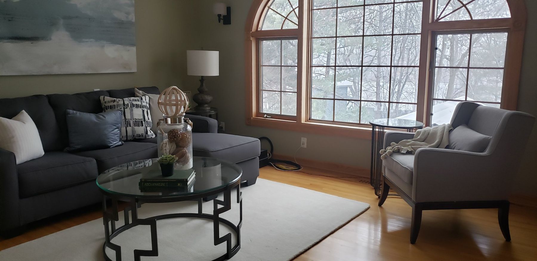 Before: Living room: oak window casings on the arched windows painted white
