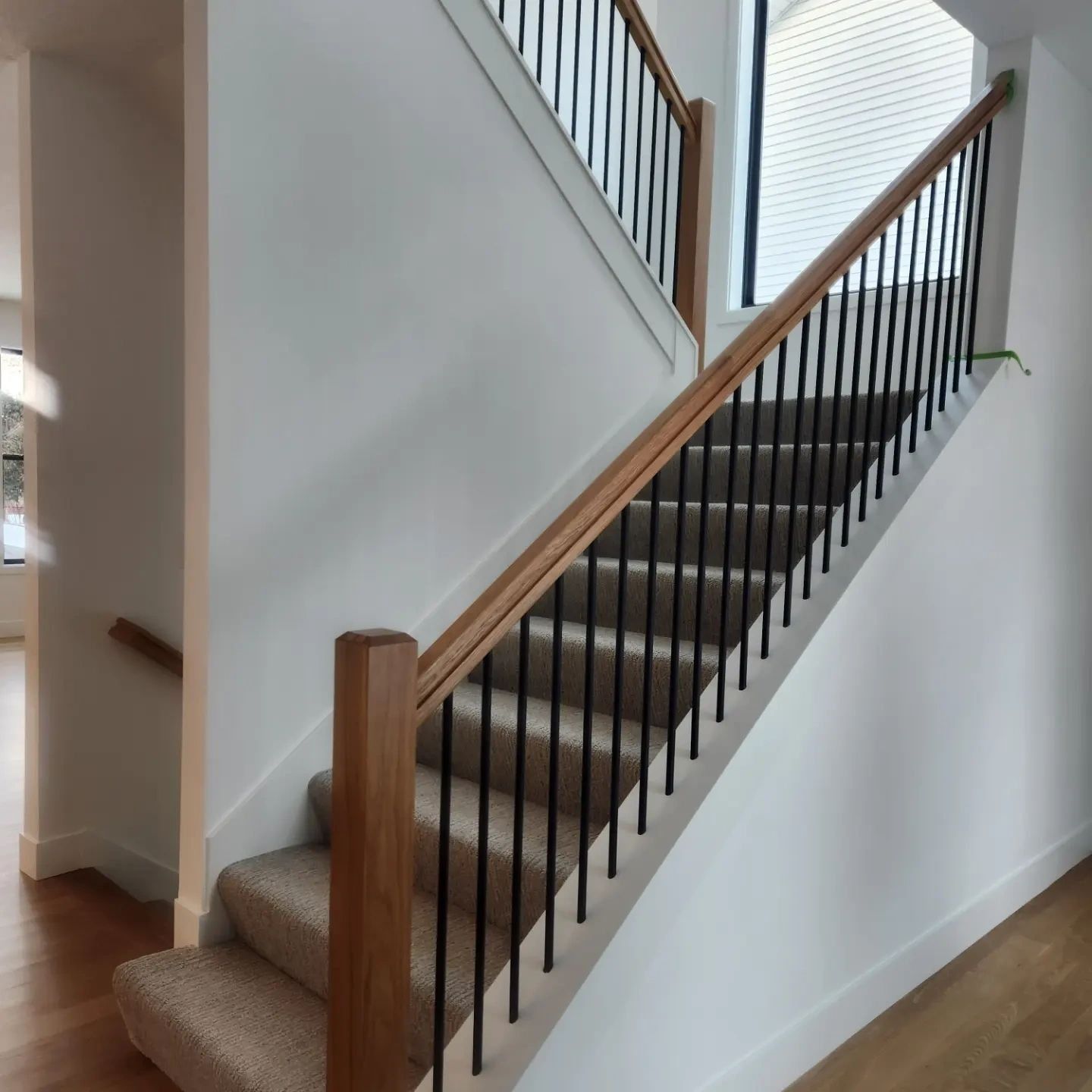 Painted stair skirt with a stained handrail and black balusters